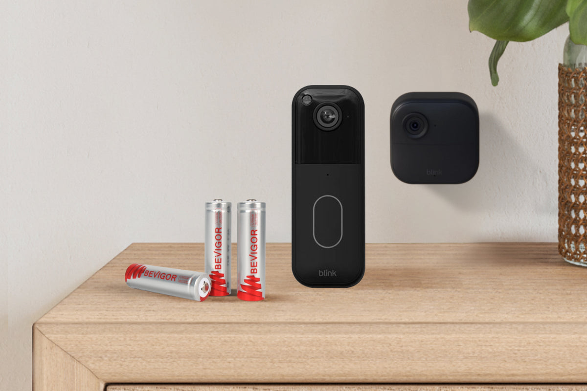 AA batteries arranged beside a battery-powered home security camera.